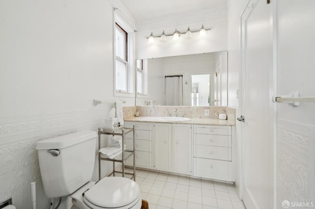 bathroom featuring wainscoting, vanity, toilet, and tile patterned floors