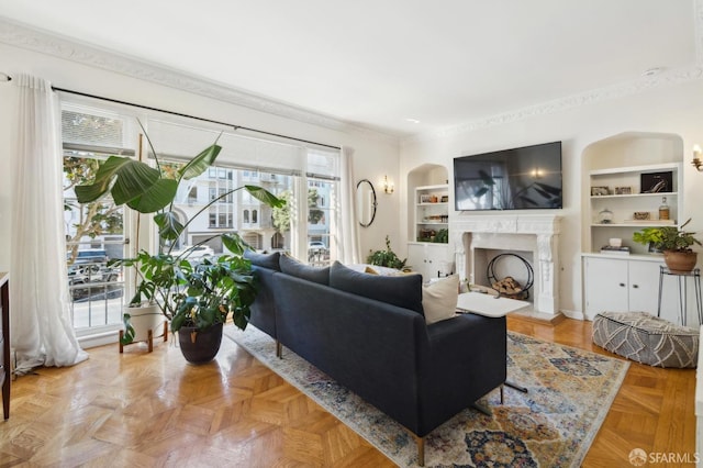 living room featuring built in features, a fireplace, and ornamental molding