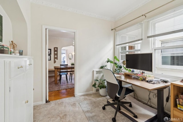 home office with arched walkways, baseboards, and crown molding