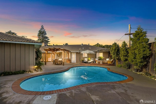 pool at dusk featuring outdoor lounge area, a pergola, and a patio