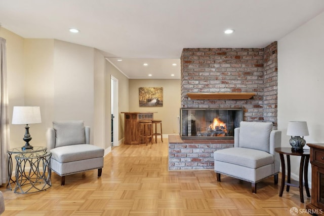 living area featuring a brick fireplace and light parquet floors