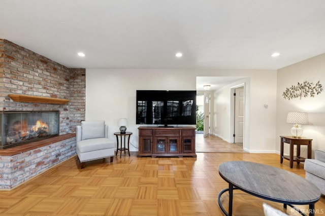 living room featuring a brick fireplace and light parquet floors