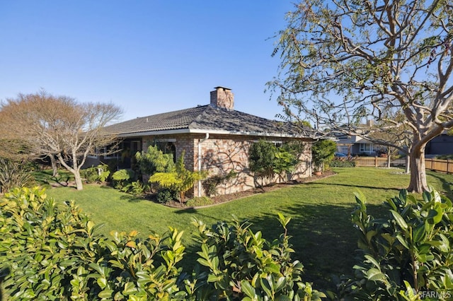 view of side of home with a yard