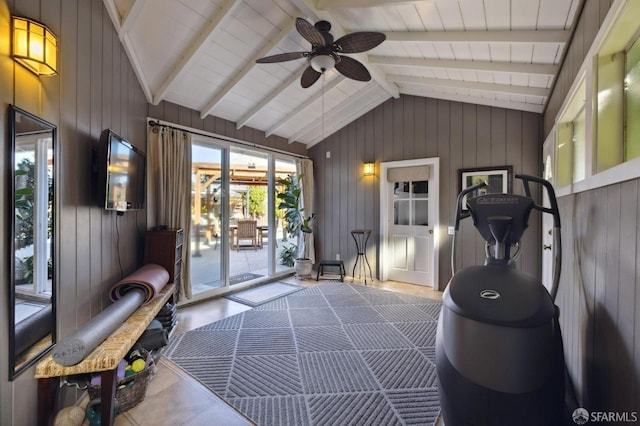 exercise room featuring ceiling fan, wooden walls, and vaulted ceiling