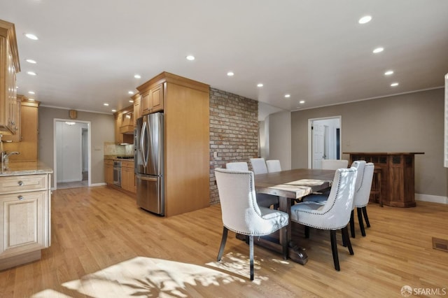 dining area with crown molding and light wood-type flooring