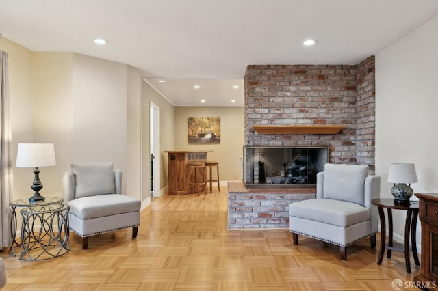 living room with a brick fireplace and light parquet flooring