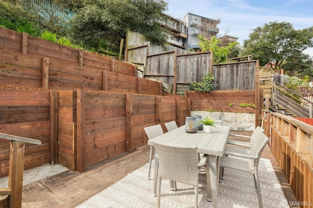 view of patio with outdoor dining space and fence