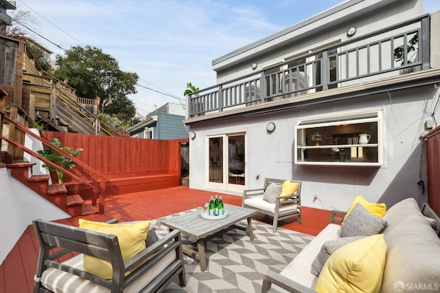 exterior space with a balcony, an outdoor living space, and fence