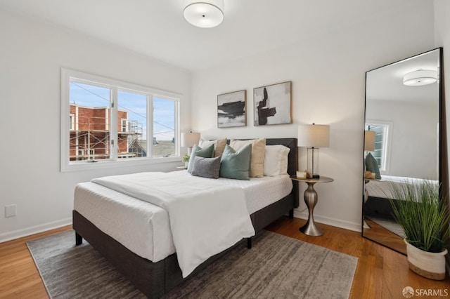 bedroom with baseboards and wood finished floors