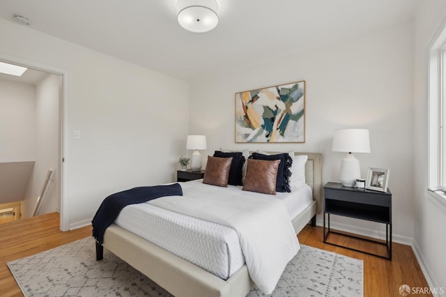 bedroom featuring baseboards and wood finished floors