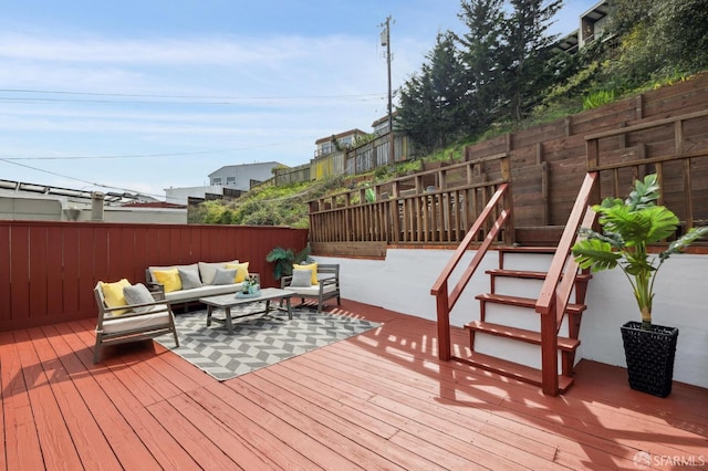 wooden terrace with an outdoor hangout area and a fenced backyard