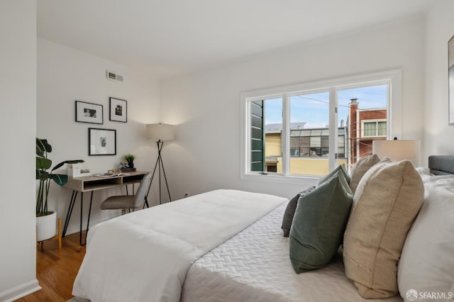 bedroom featuring visible vents and wood finished floors