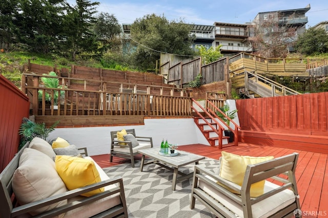 view of patio featuring stairway, fence, an outdoor hangout area, and a wooden deck