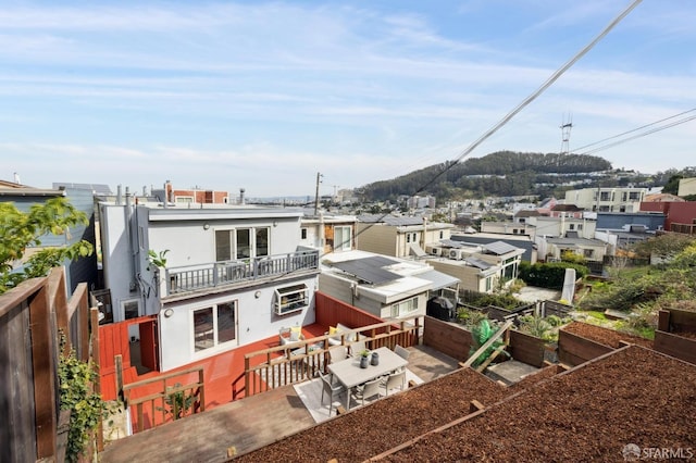 back of property with a vegetable garden, a fenced backyard, a balcony, and stucco siding