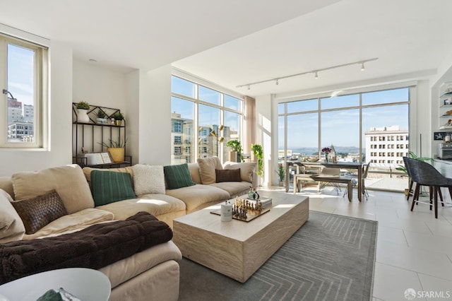 tiled living room featuring track lighting and floor to ceiling windows