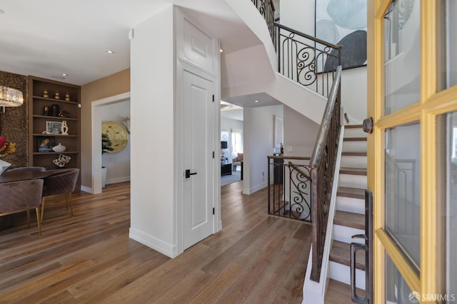 foyer featuring stairs, baseboards, and wood finished floors