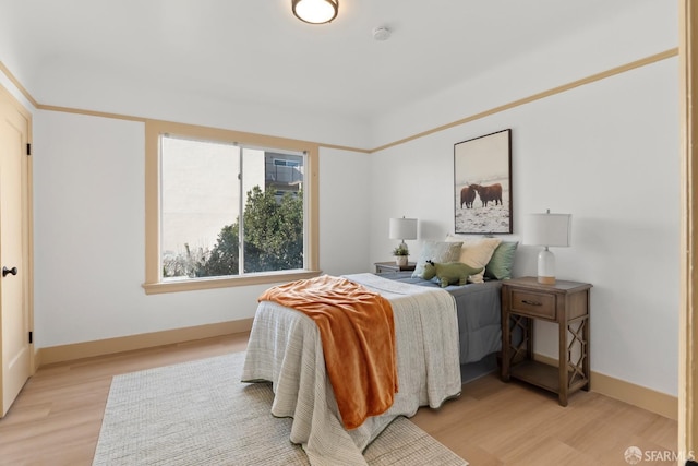 bedroom featuring baseboards and light wood finished floors
