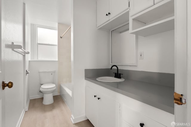 full bathroom featuring wood finished floors, vanity, toilet, and baseboards