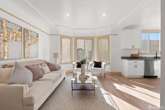 living area featuring light wood-type flooring, baseboards, and recessed lighting