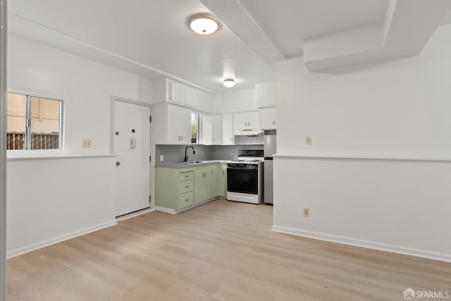 kitchen with light wood-style floors, gas range, under cabinet range hood, green cabinets, and a sink