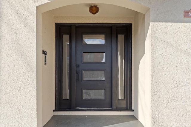 view of exterior entry with stucco siding