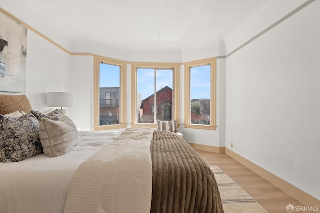 bedroom with light wood finished floors and baseboards