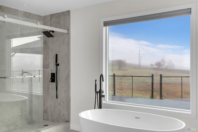 bathroom with a wealth of natural light, a rural view, and plus walk in shower