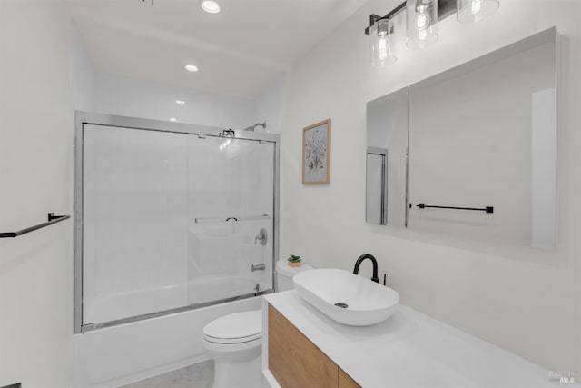 full bathroom featuring toilet, bath / shower combo with glass door, and vanity