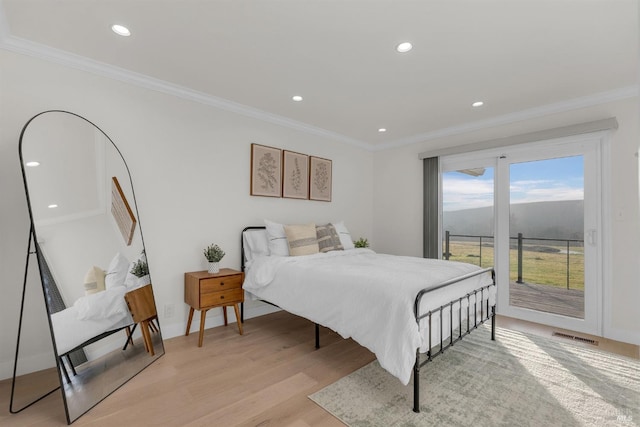 bedroom featuring ornamental molding, light hardwood / wood-style floors, and access to outside