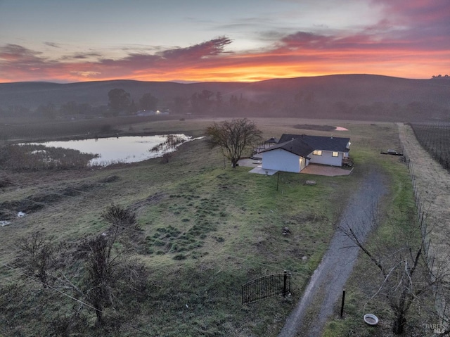 aerial view at dusk with a rural view and a water and mountain view