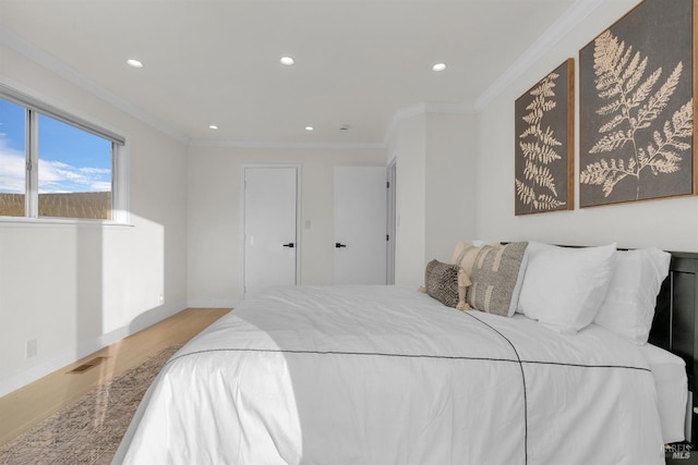 bedroom with light hardwood / wood-style floors and crown molding