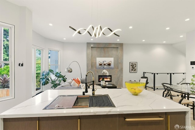 4038 18th St, San Francisco, CA 94114 - kitchen with open floor plan, an island with sink, recessed lighting, a fireplace, and light stone countertops