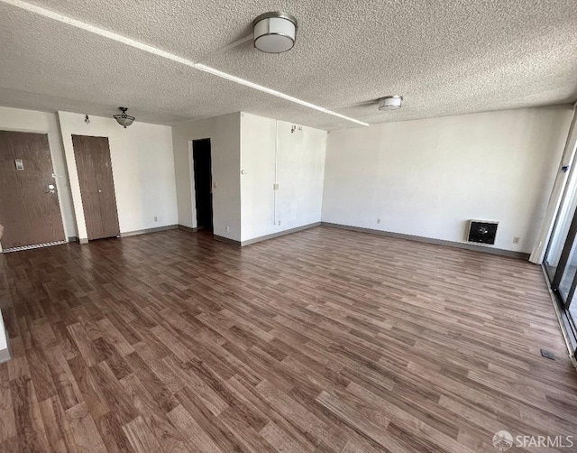 spare room with a textured ceiling and hardwood / wood-style flooring