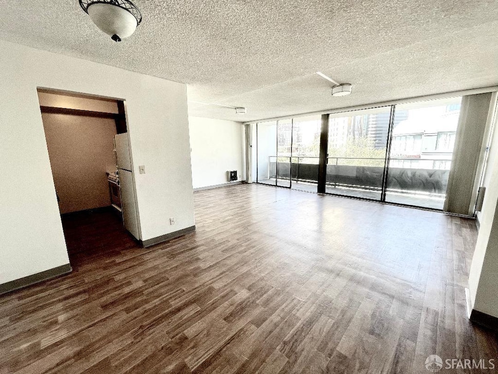 interior space featuring a textured ceiling, access to outside, dark hardwood / wood-style flooring, and expansive windows