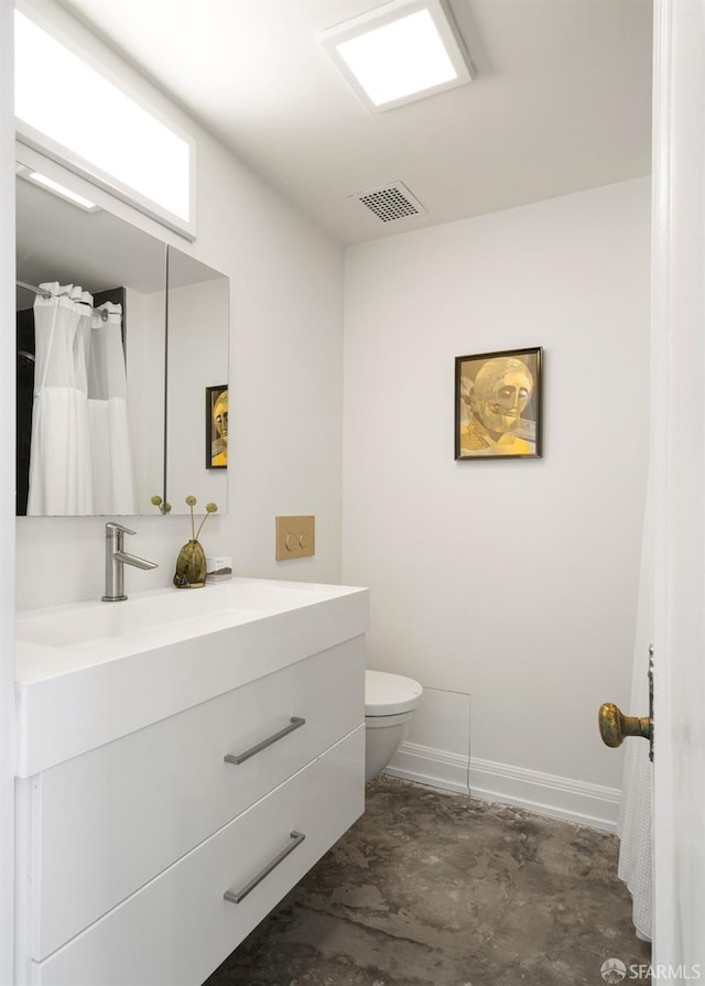 bathroom featuring vanity, toilet, and concrete floors