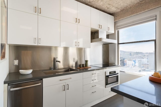 kitchen featuring sink, white cabinetry, stainless steel appliances, dark hardwood / wood-style floors, and decorative backsplash