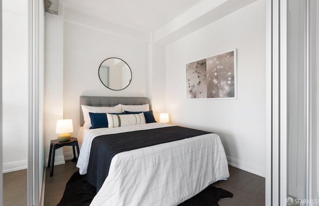 bedroom with dark wood-type flooring