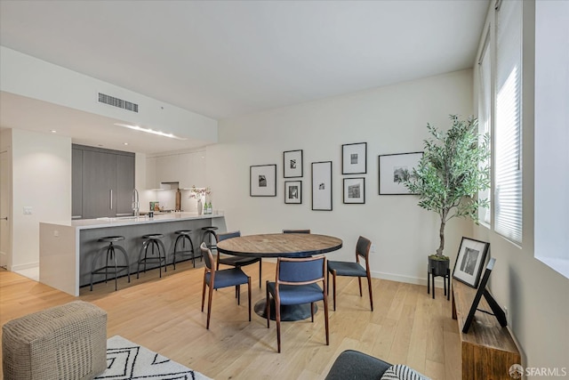 dining room featuring light hardwood / wood-style flooring, plenty of natural light, and sink