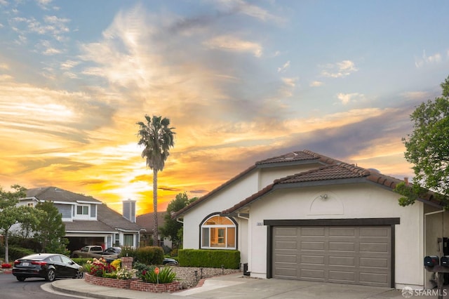 view of front facade featuring driveway, an attached garage, and stucco siding