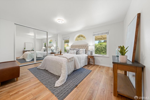bedroom with wood-type flooring and baseboards