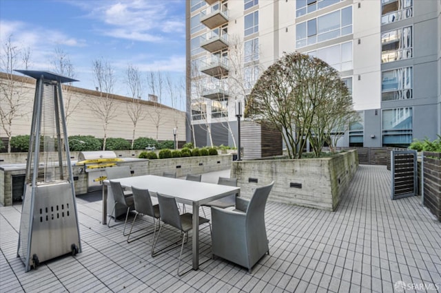 view of patio with outdoor dining area, an outdoor kitchen, and a grill