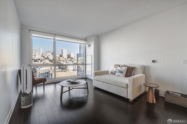 living room featuring a view of city, dark wood-style floors, and baseboards