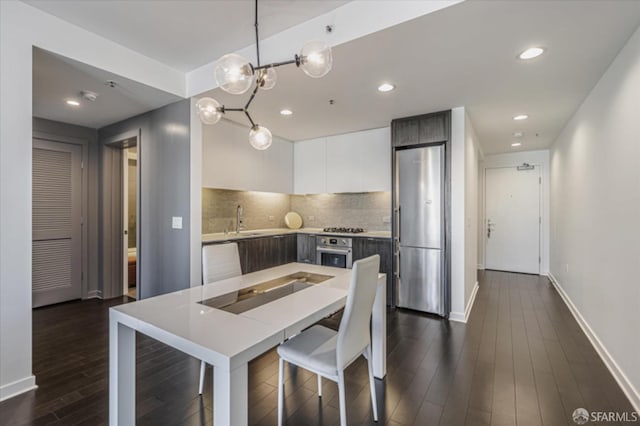 kitchen featuring a sink, white cabinets, appliances with stainless steel finishes, modern cabinets, and dark wood finished floors