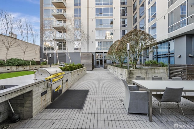 view of property's community with outdoor dining space and area for grilling