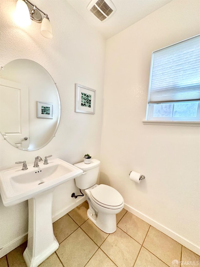 bathroom with toilet and tile patterned flooring