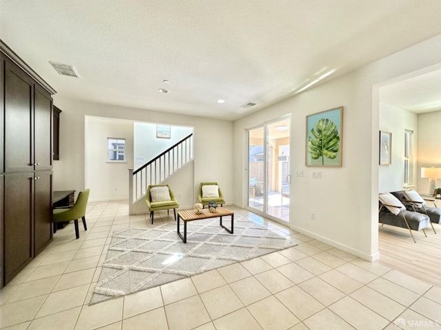 living area featuring a textured ceiling and light tile patterned floors