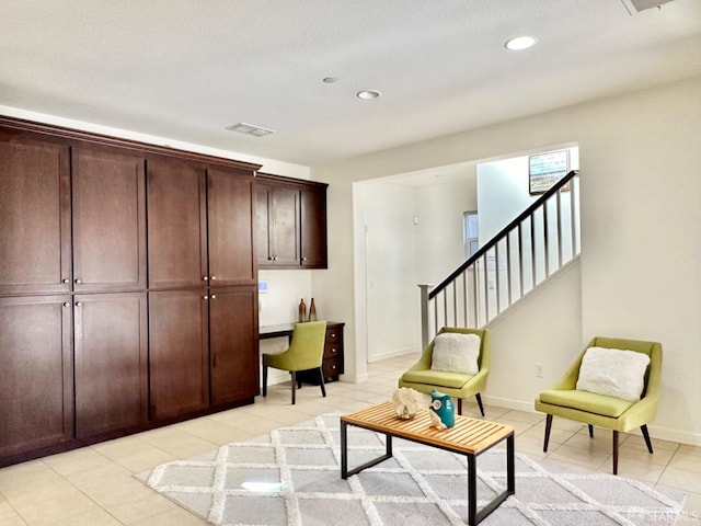 living area with a textured ceiling and light tile patterned flooring