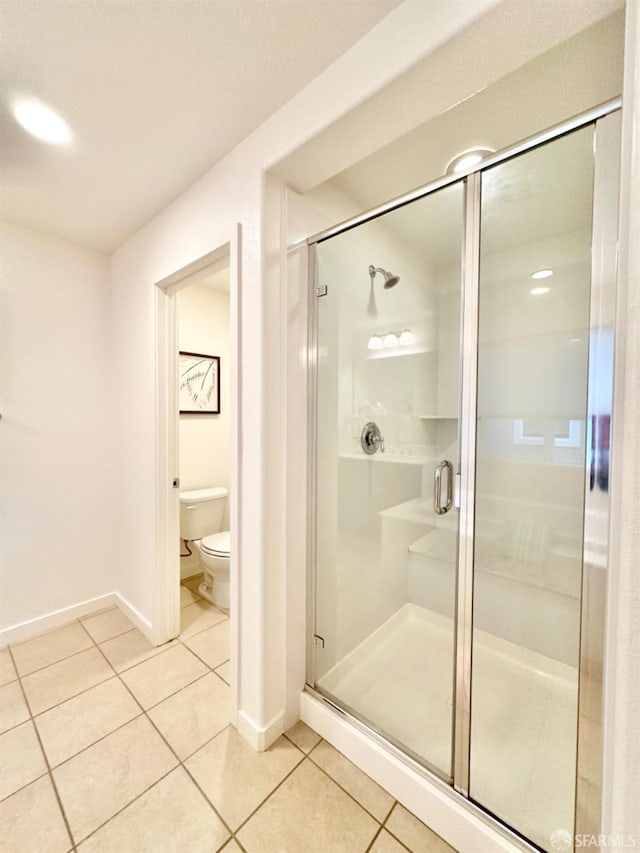 bathroom with tile patterned floors, a shower with shower door, and toilet