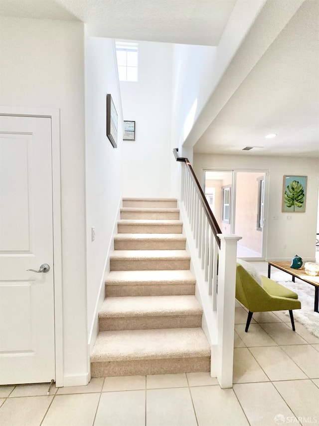 stairway featuring tile patterned flooring