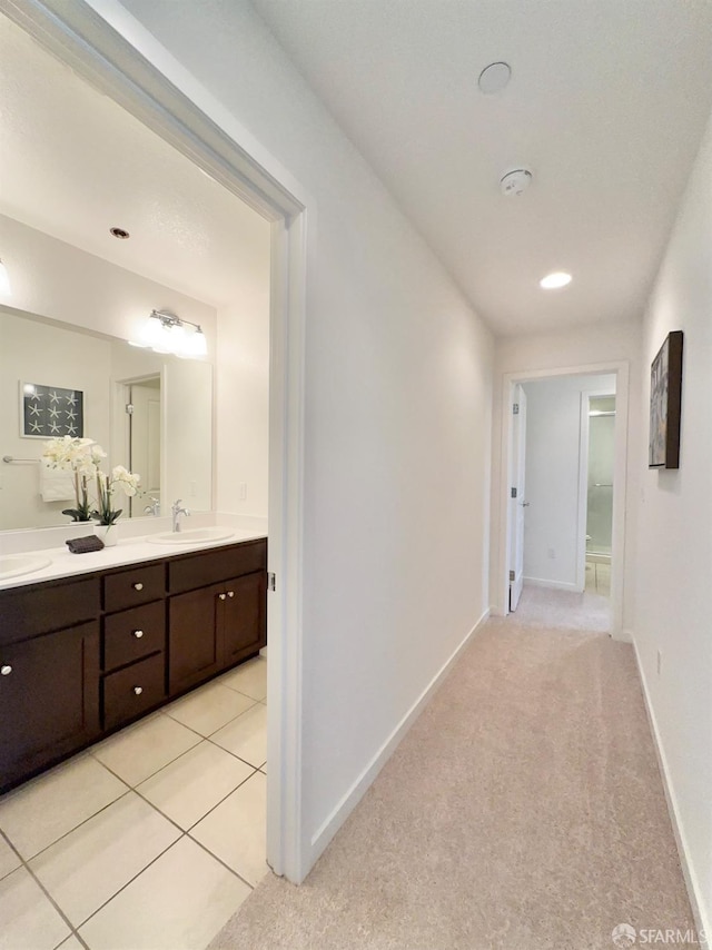 hall featuring light carpet and sink